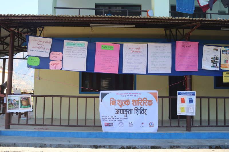 Health post with a banner for the free physical disability camp and information posters