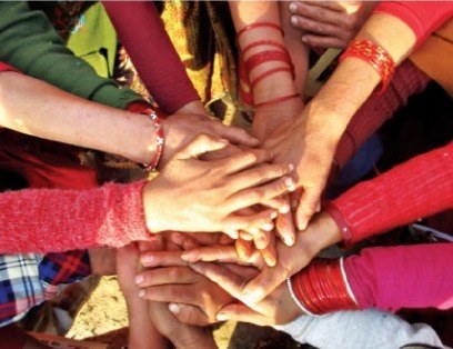 Hands of community members stacked together in a circle